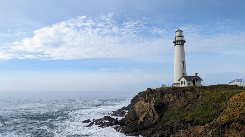 a lighthouse on top of a cliff next to the ocean