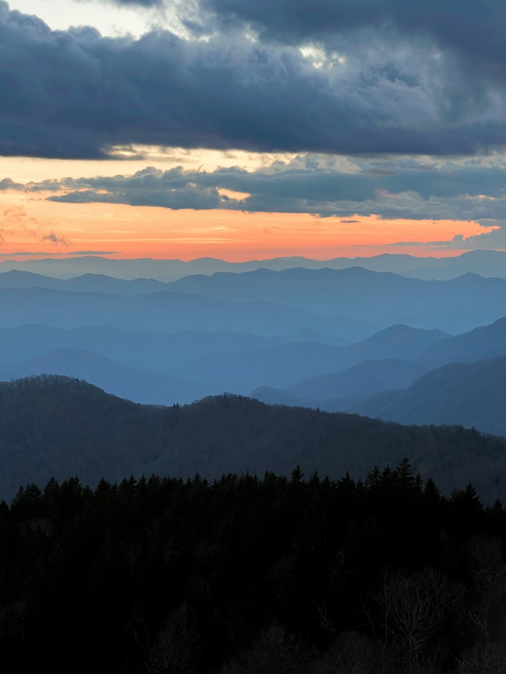 a view of the mountains at sunset from the top of a hill