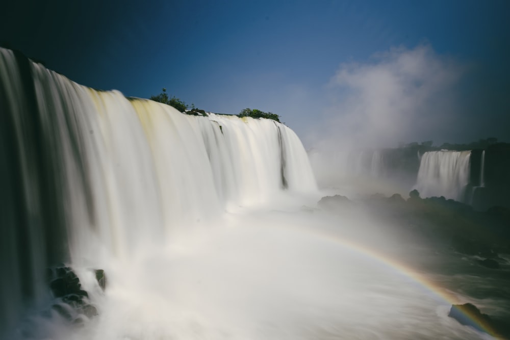 a waterfall with a rainbow in the middle of it