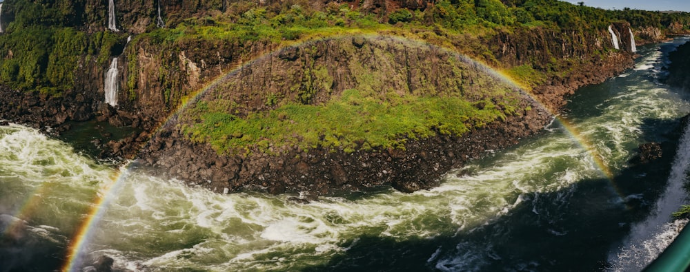 a rainbow in the sky over a waterfall
