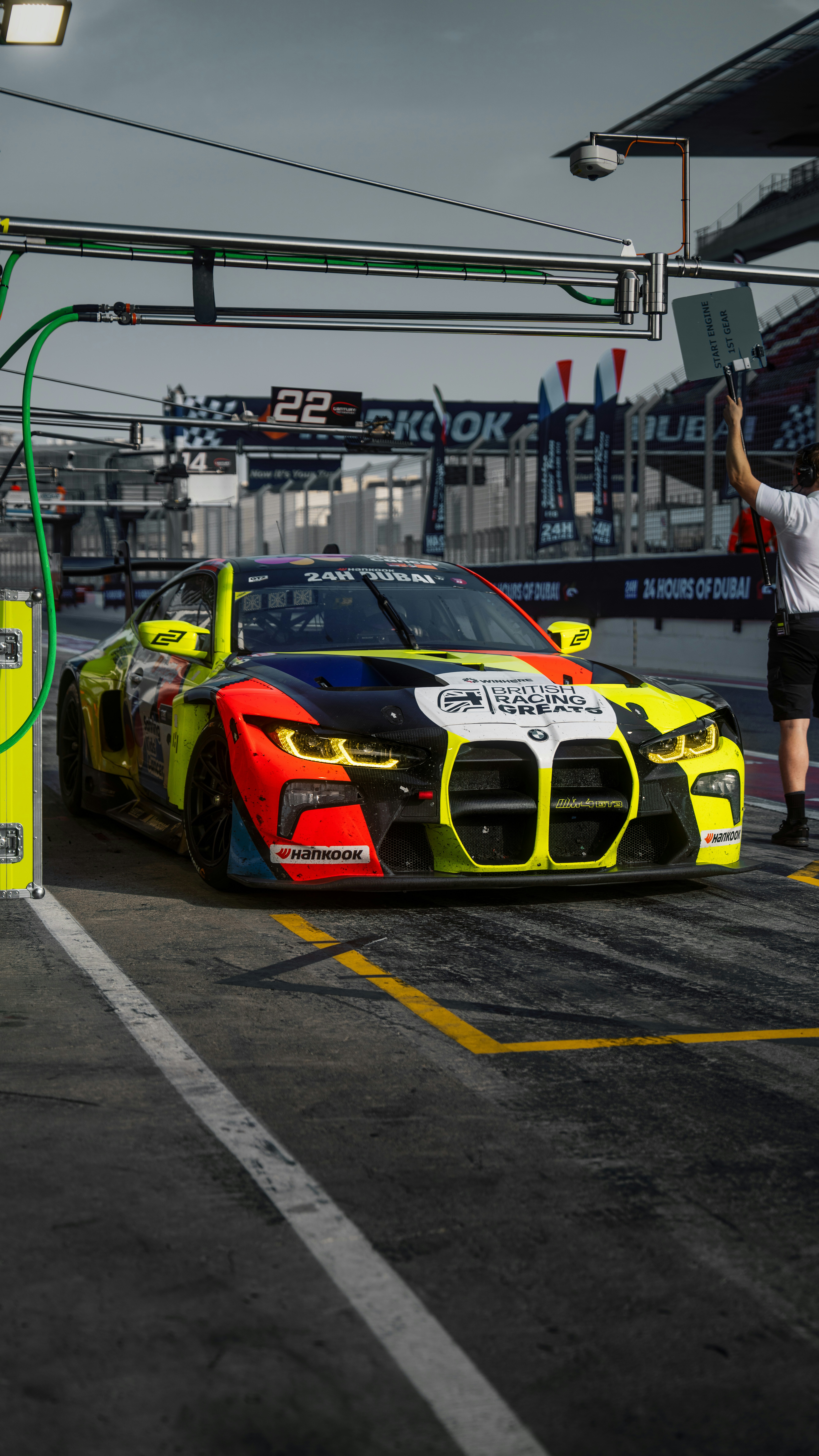 un uomo in piedi accanto a un'auto da corsa in un parcheggio