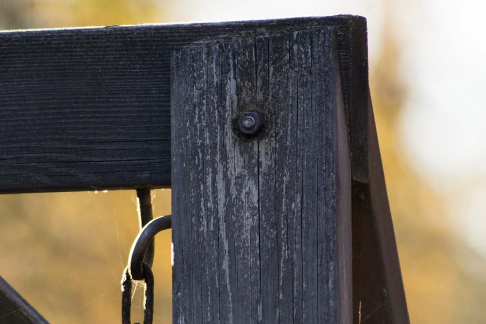 a close up of a wooden fence with a chain on it