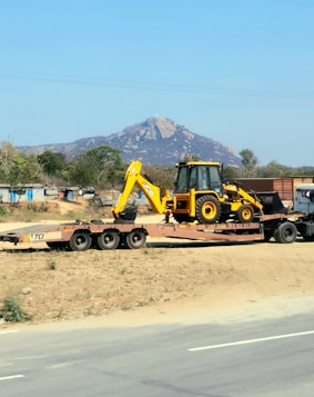 a tractor trailer hauling a load of construction equipment