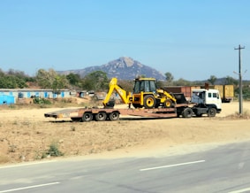 a tractor trailer hauling a load of construction equipment