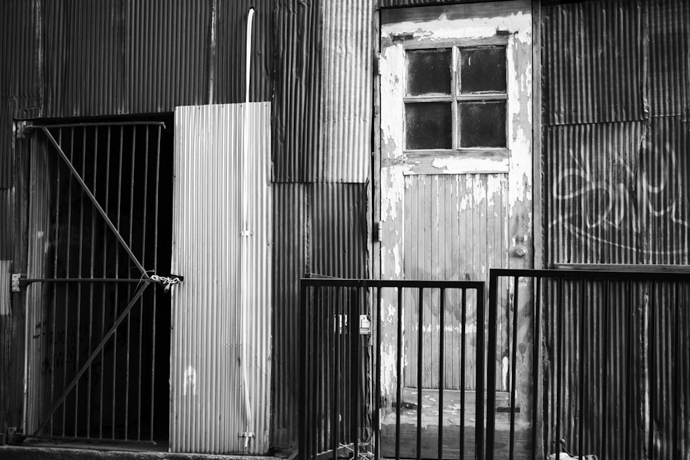 uma foto em preto e branco de um portão e um prédio