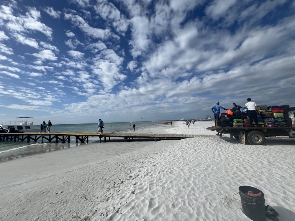 a group of people standing on a beach next to the ocean