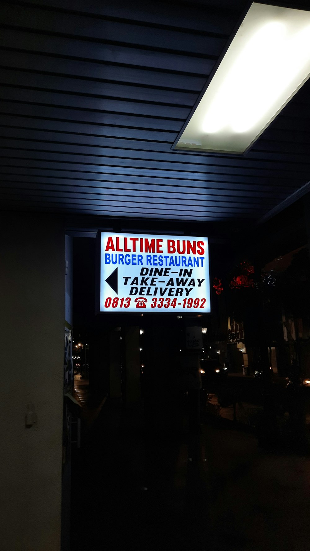 a restaurant sign is lit up in the dark