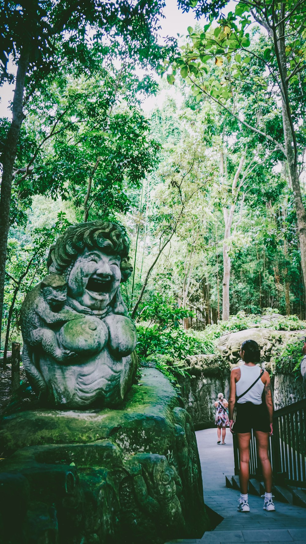 a woman standing next to a stone lion statue