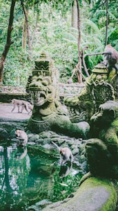 a group of statues sitting next to a body of water
