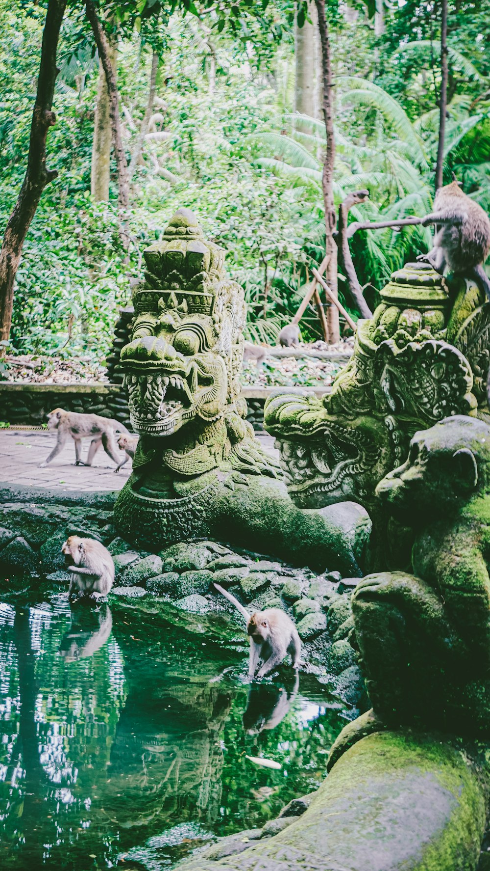 um grupo de estátuas sentadas ao lado de um corpo de água