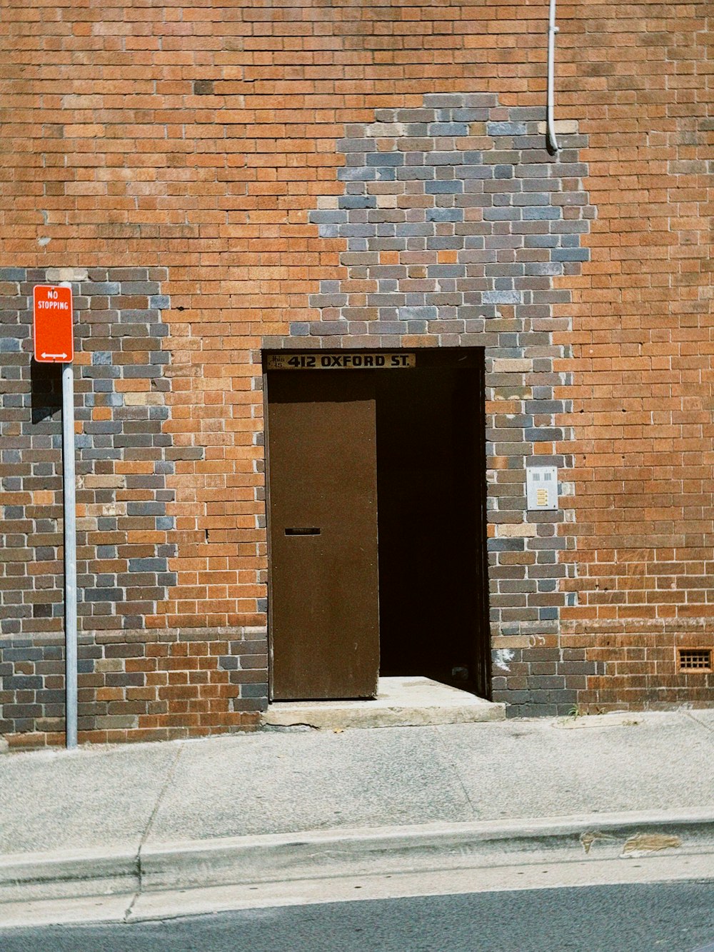 a red fire hydrant sitting next to a brick building