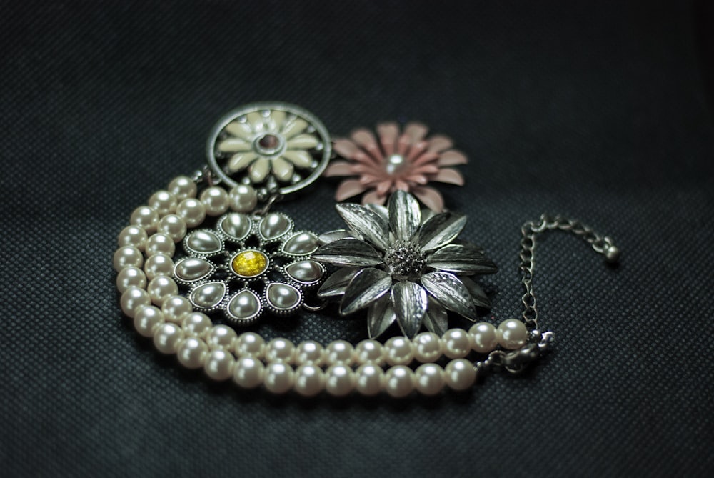 a close up of a necklace with flowers on it