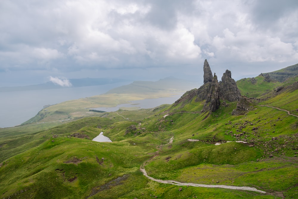 Una vista panorámica de una montaña verde con un lago en la distancia