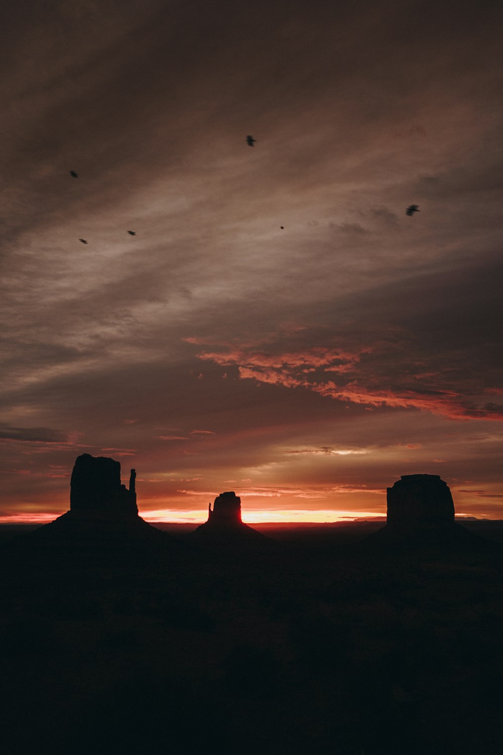 Il sole sta tramontando sul deserto con le rocce in primo piano