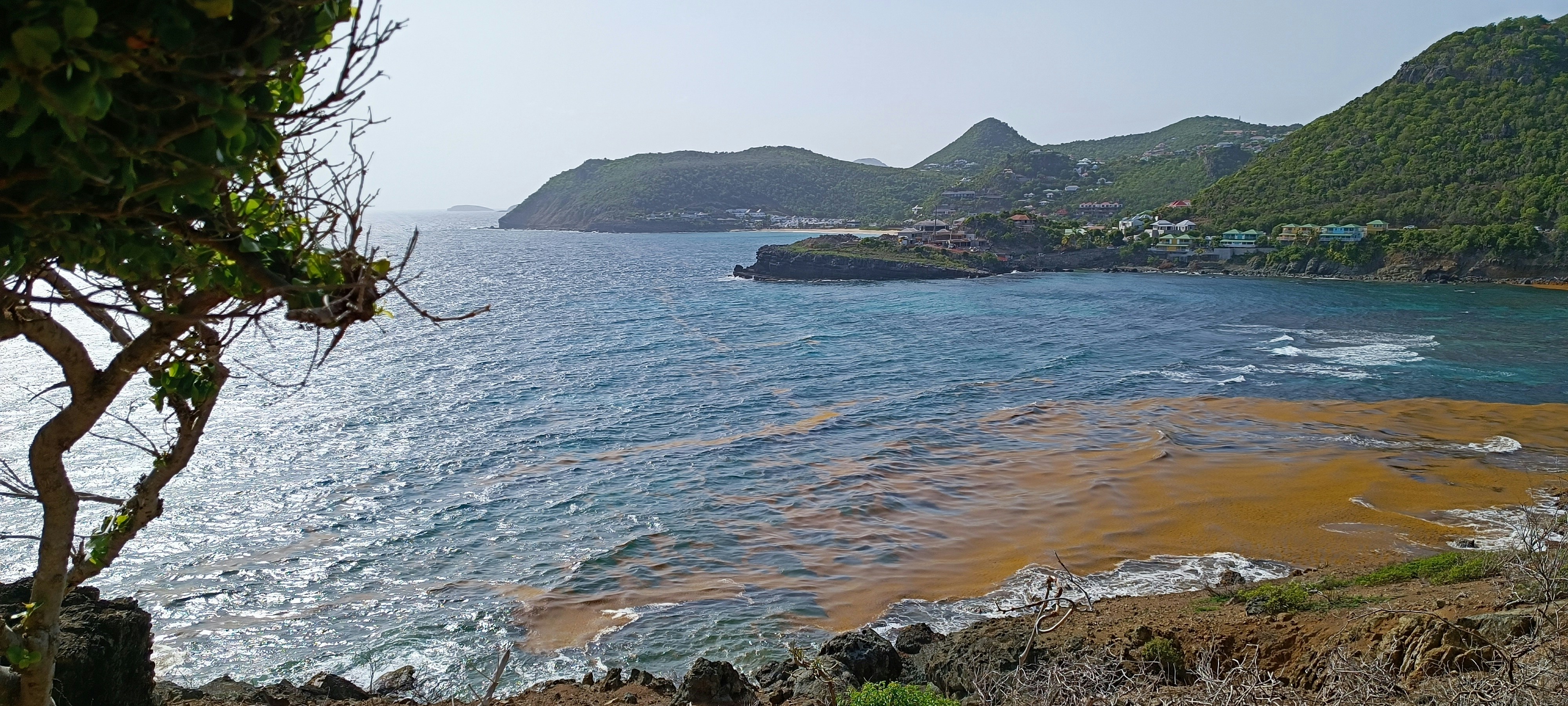 a body of water surrounded by a lush green hillside