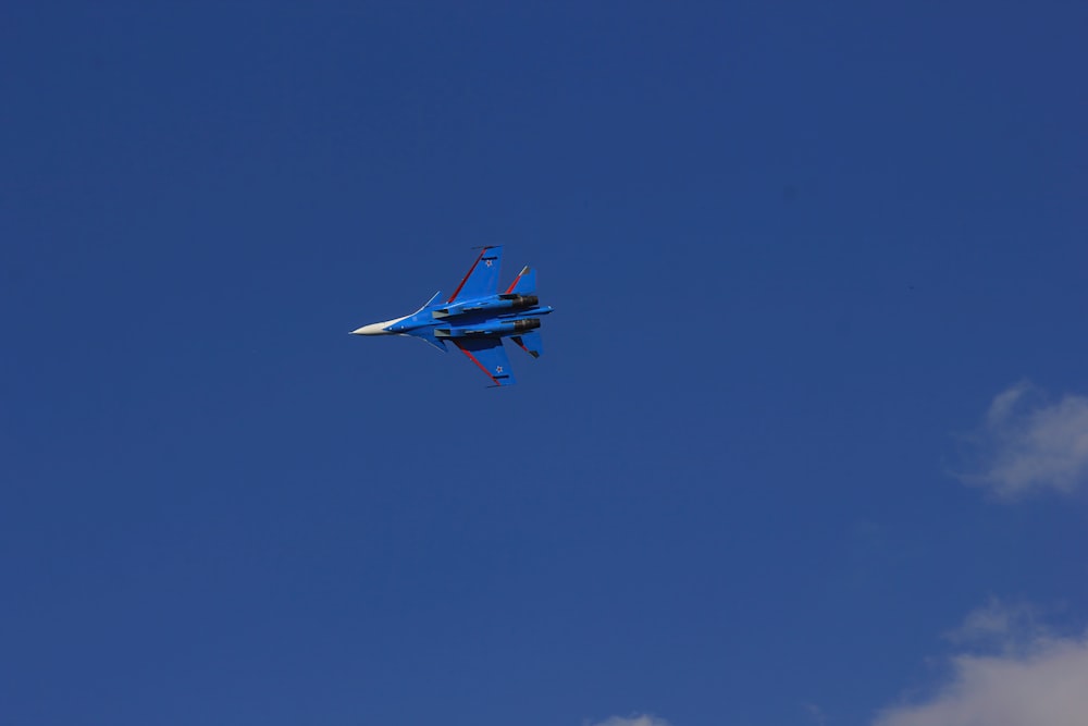 a fighter jet flying through a blue sky