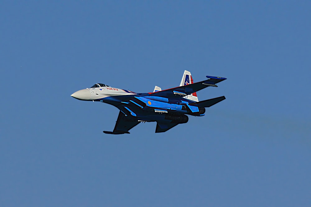 a fighter jet flying through a blue sky