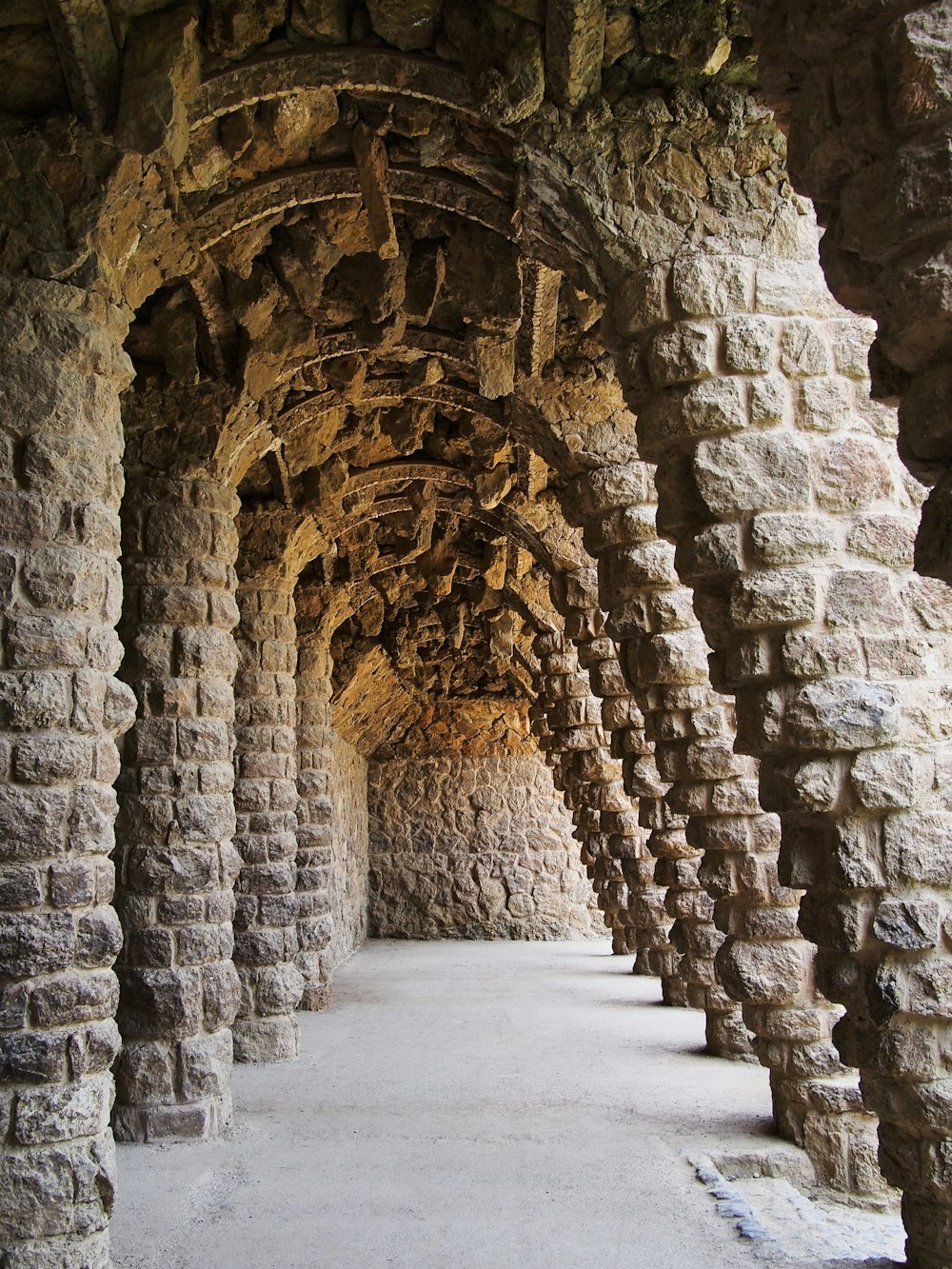 a very long tunnel with a bunch of stone pillars