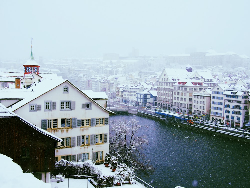 a snowy view of a river running through a city
