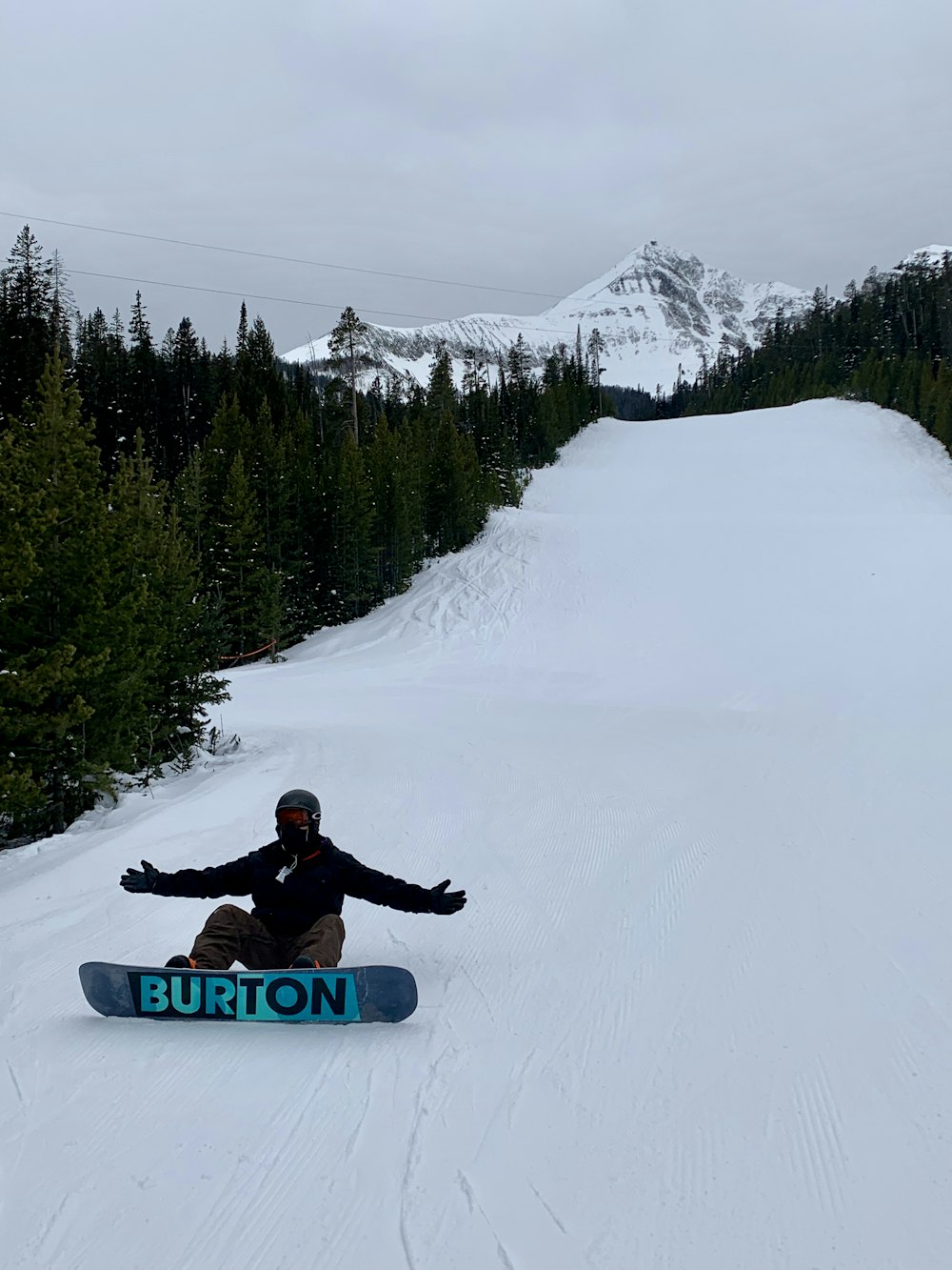 a man riding a snowboard down a snow covered slope