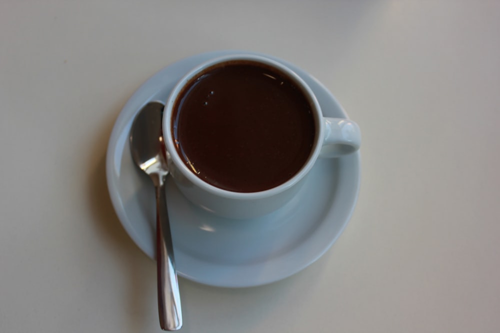 una tazza di caffè con un cucchiaio su un piattino