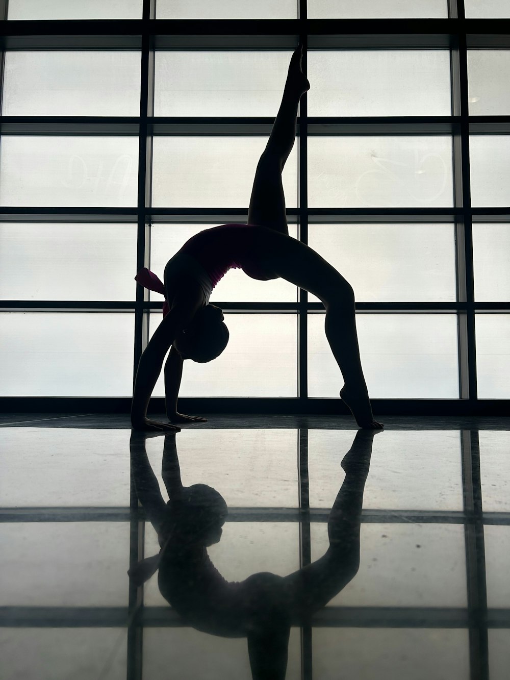 a person doing a handstand in front of a window