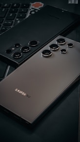 a close up of a cell phone near a keyboard