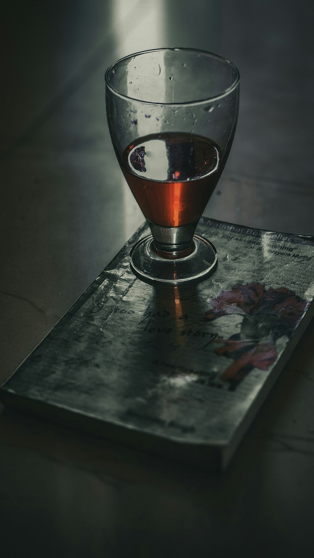 a glass of tea sitting on top of a book