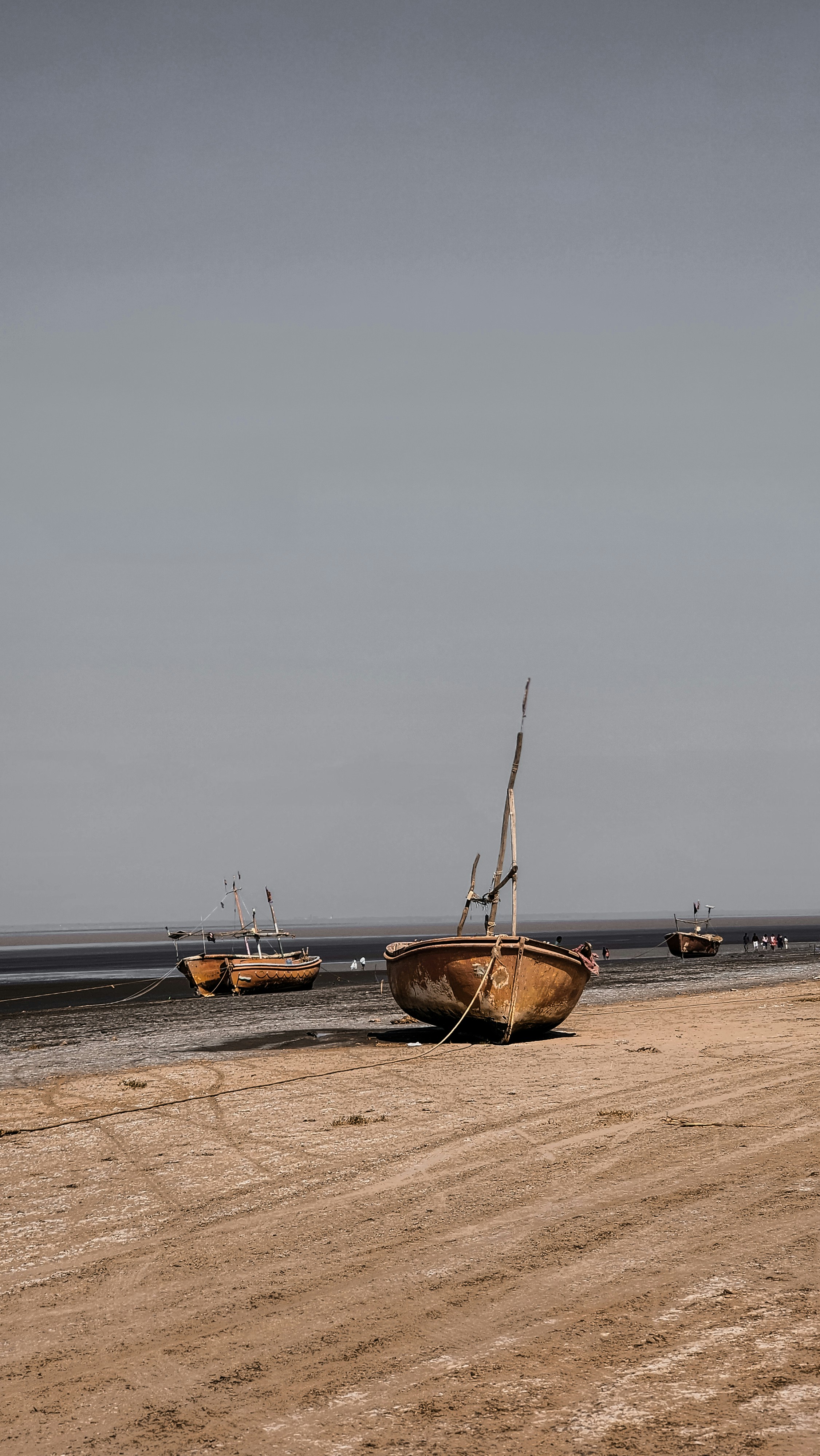 a couple of boats sitting on top of a sandy beach