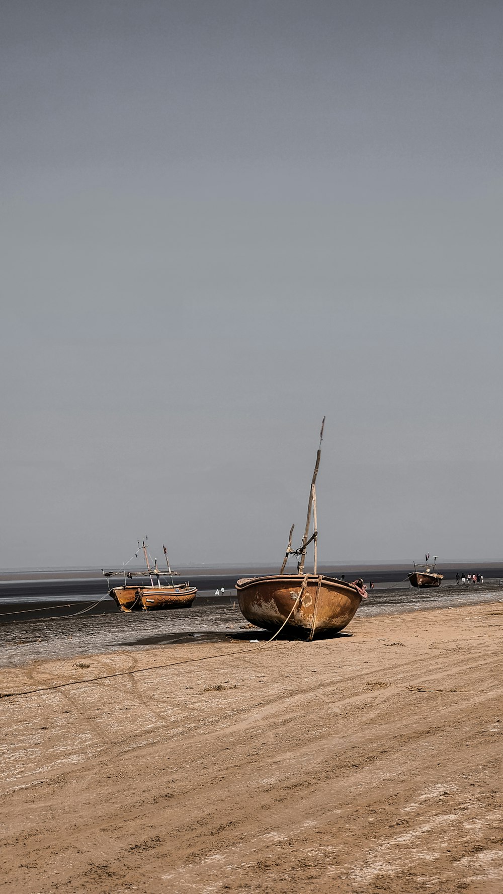 ein paar Boote, die auf einem Sandstrand sitzen
