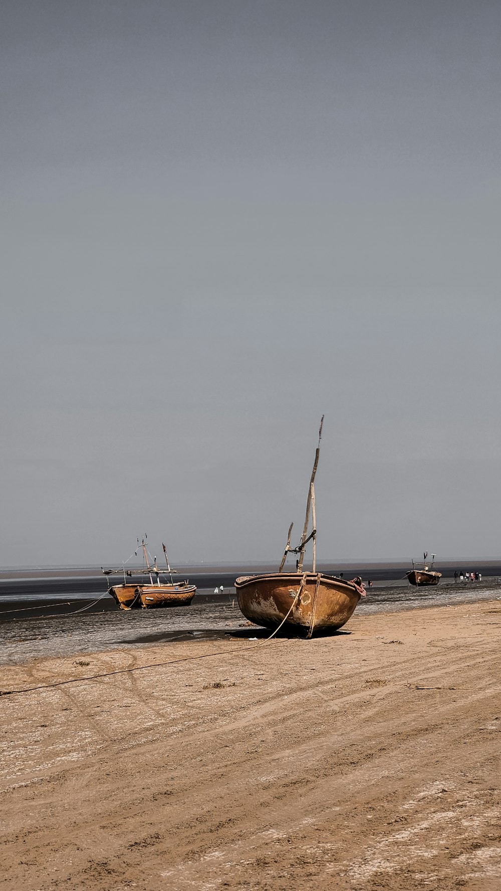 a couple of boats sitting on top of a sandy beach