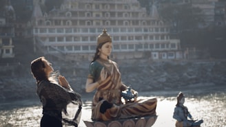 a man standing next to a statue of a woman