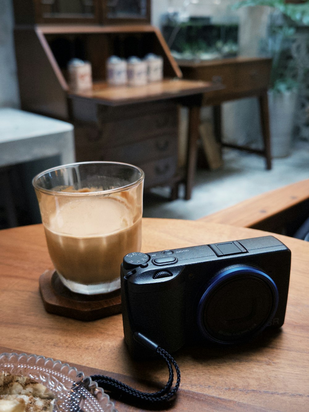 a camera sitting on a table next to a cup of coffee