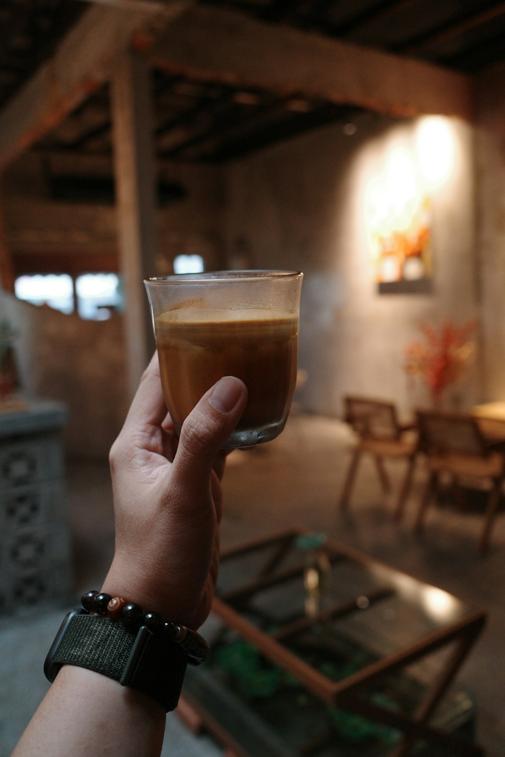 a person holding a glass of liquid in their hand