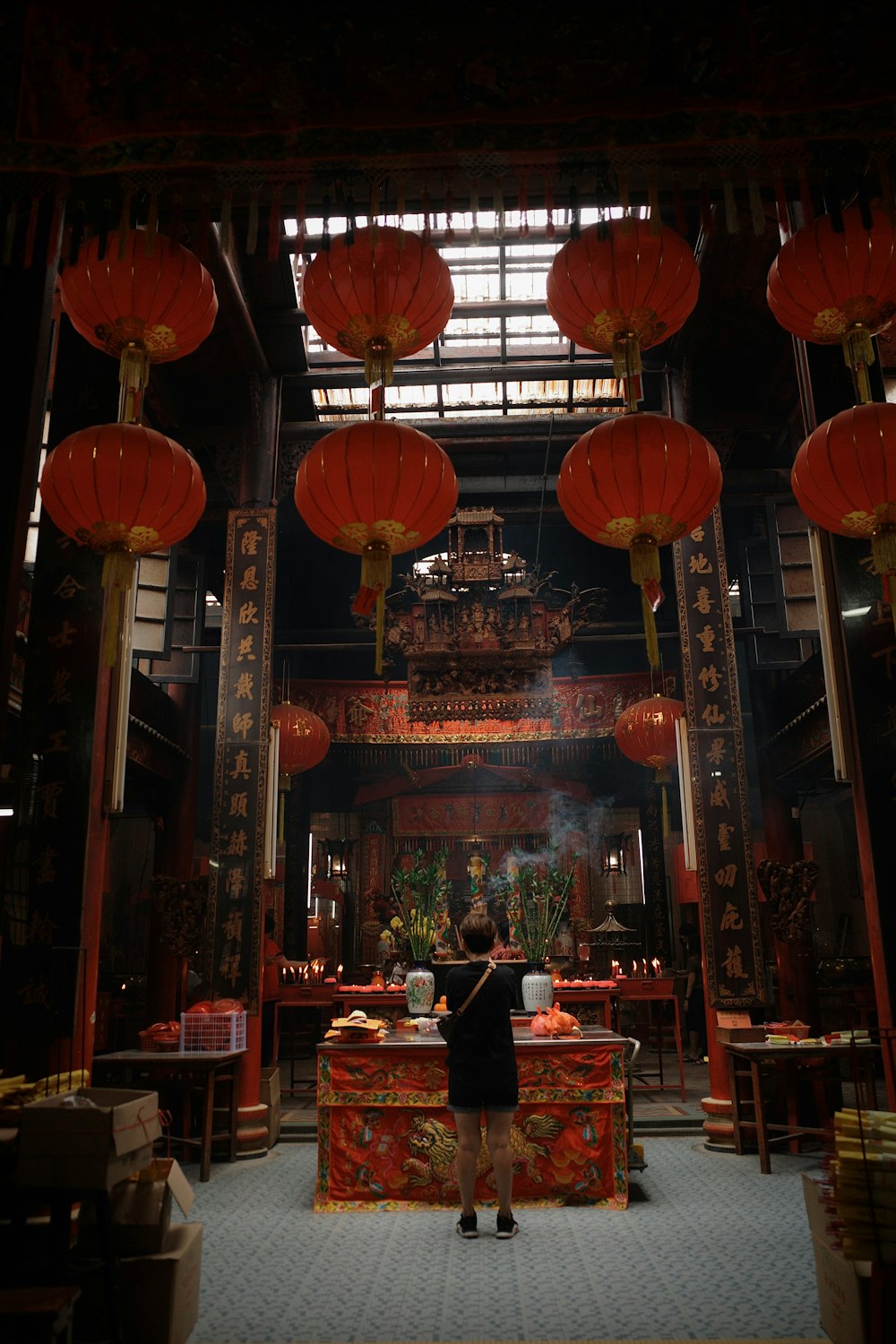 a person standing in a room with red lanterns