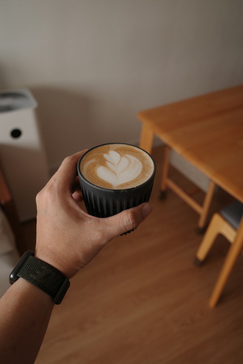 a person holding a cup of coffee in their hand