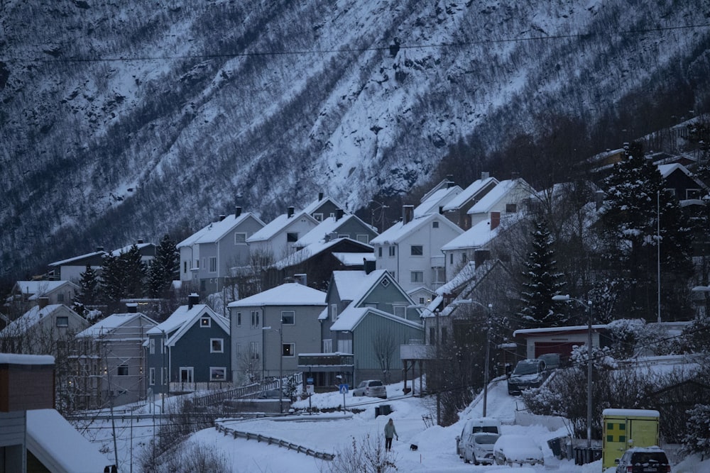 a snow covered town with a mountain in the background