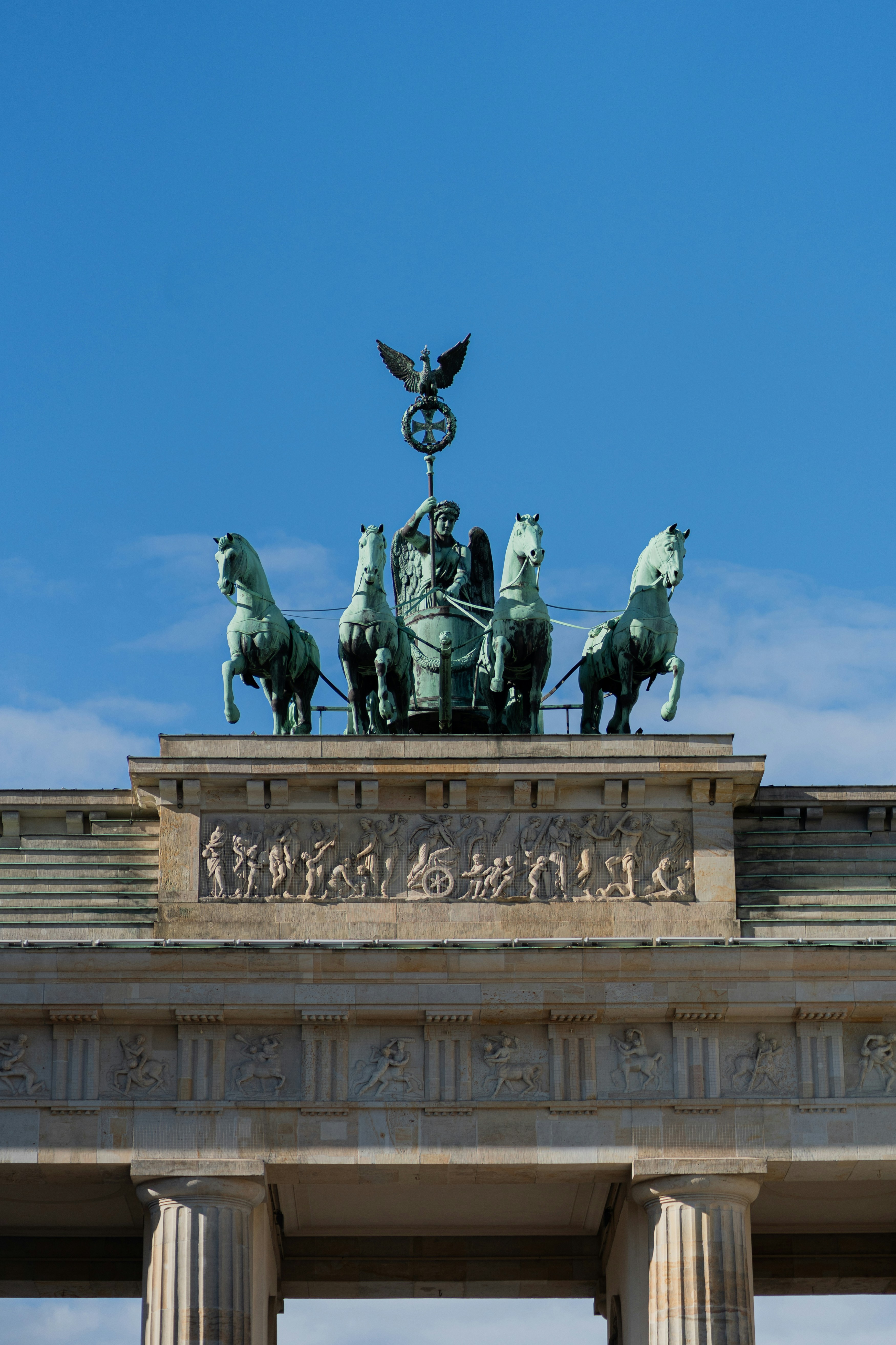 uma estátua no topo de um edifício com cavalos