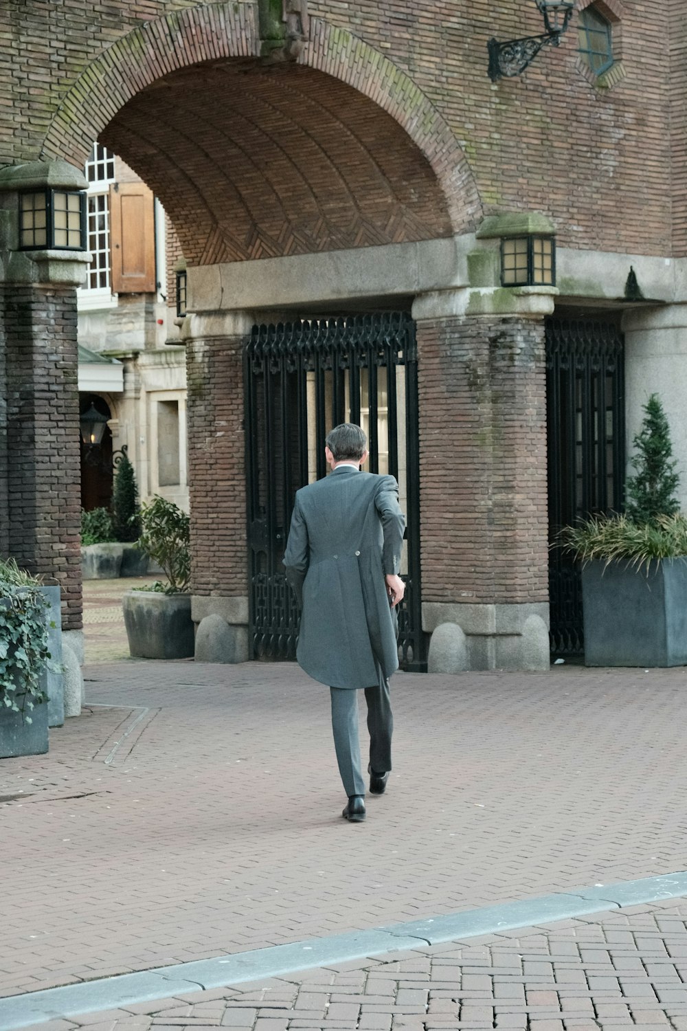 a man in a suit walking down a street