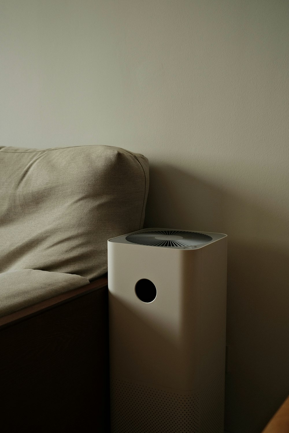 a white air conditioner sitting on top of a bed