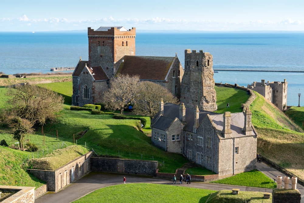 an aerial view of a castle with a body of water in the background