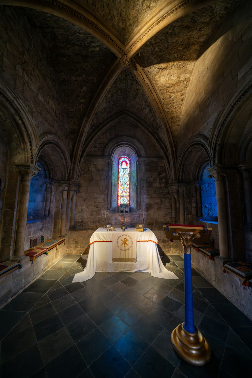 a church with a long table and a stained glass window