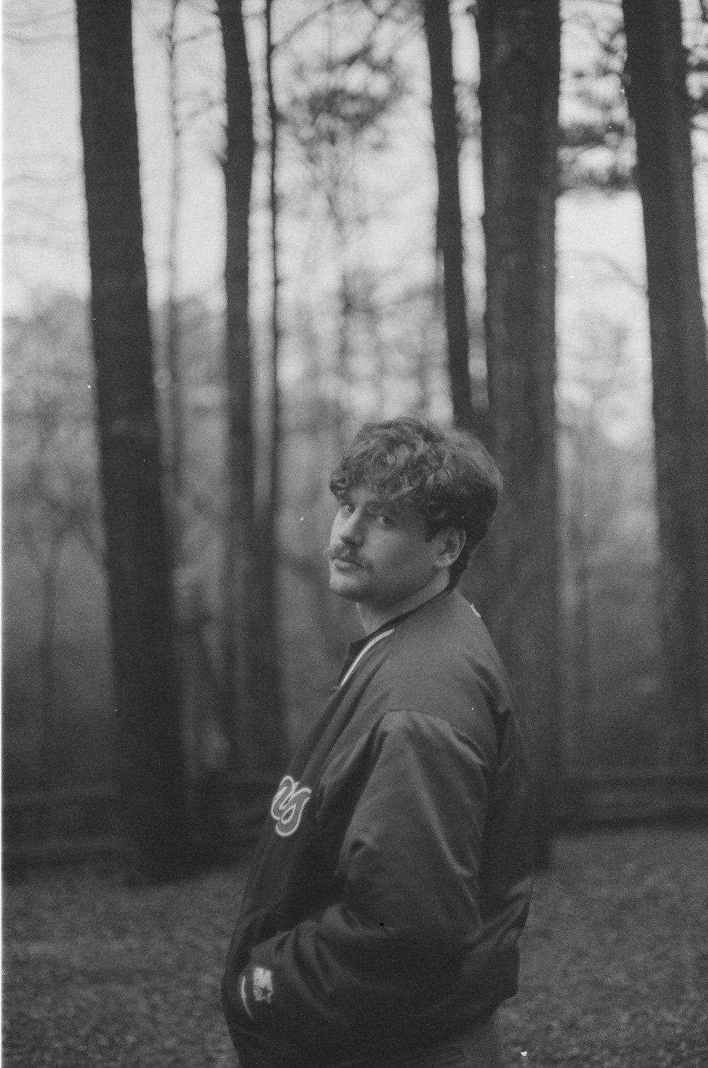a black and white photo of a man in the woods