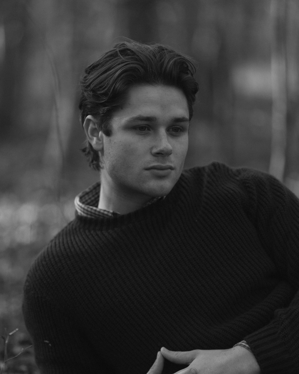 a black and white photo of a man in a sweater