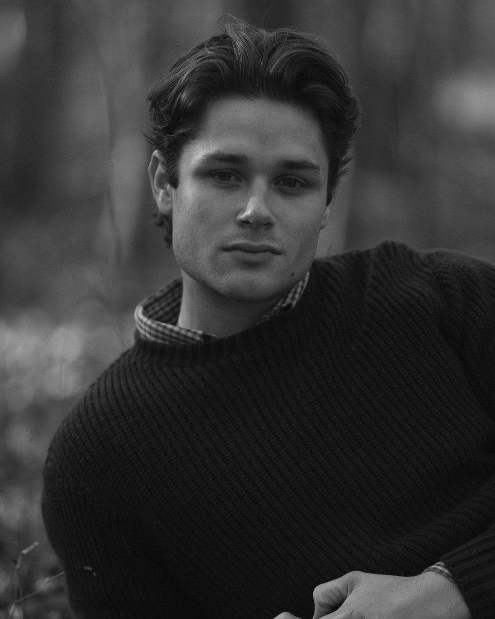 a black and white photo of a man in a sweater