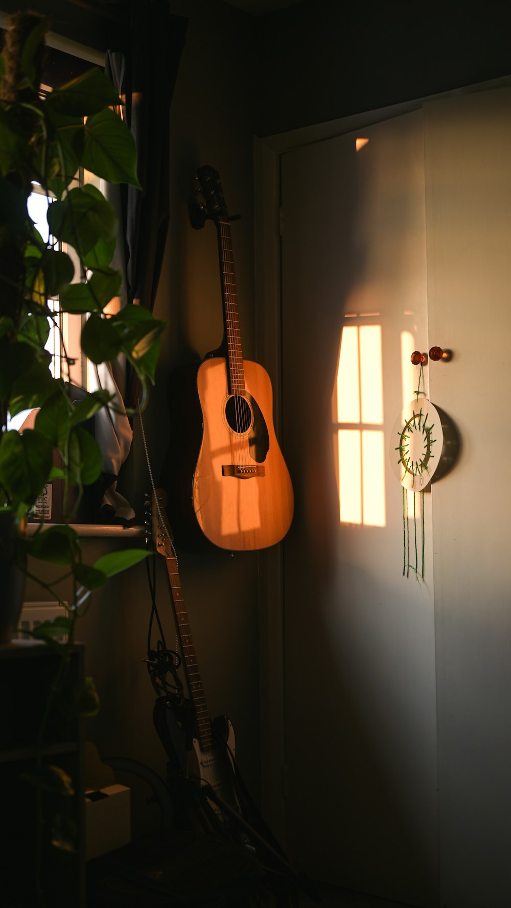 a guitar hanging on a wall next to a clock