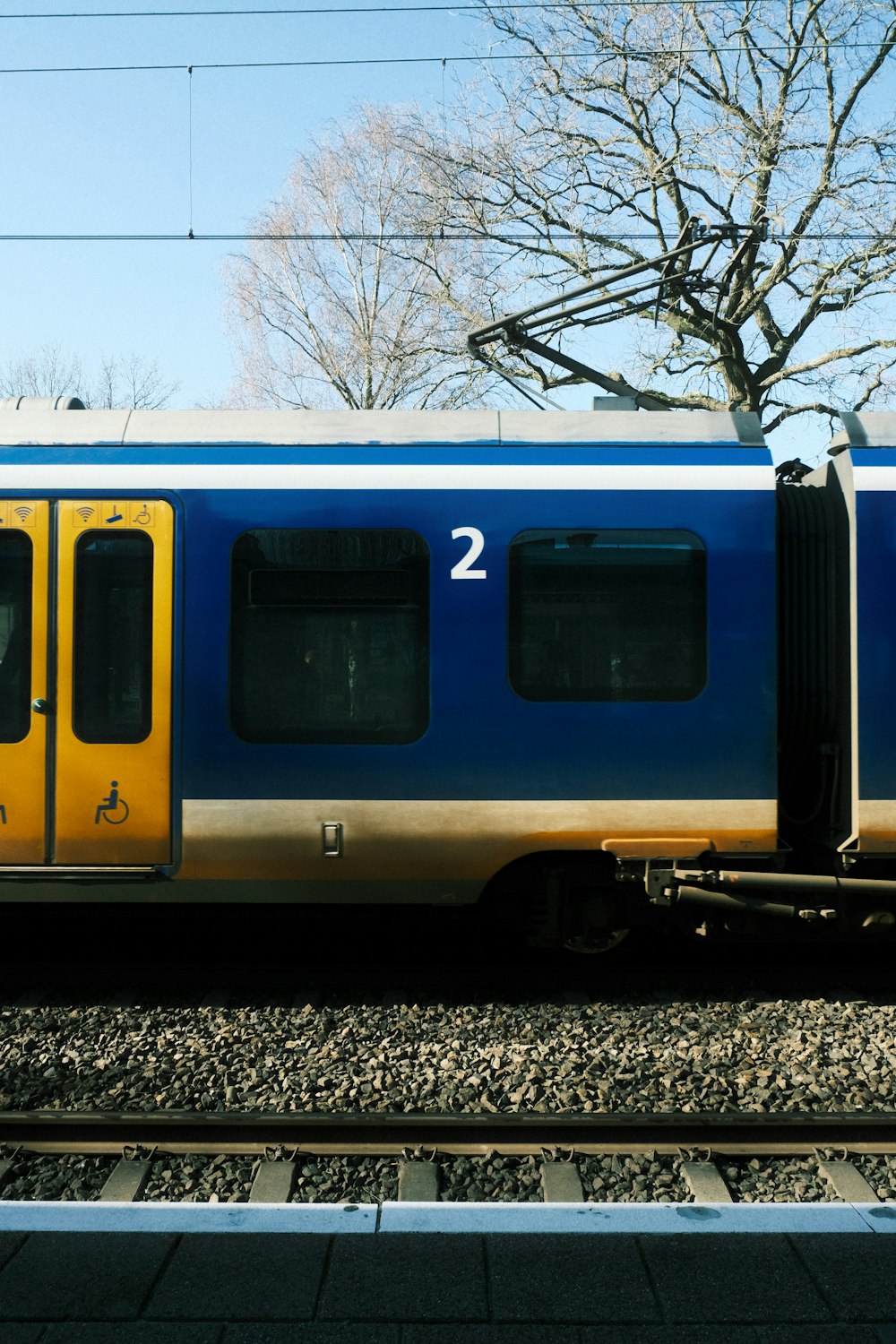 a blue and yellow train traveling down train tracks