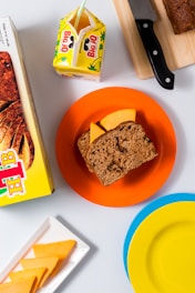 a plate with a piece of bread on it next to a box of cereal