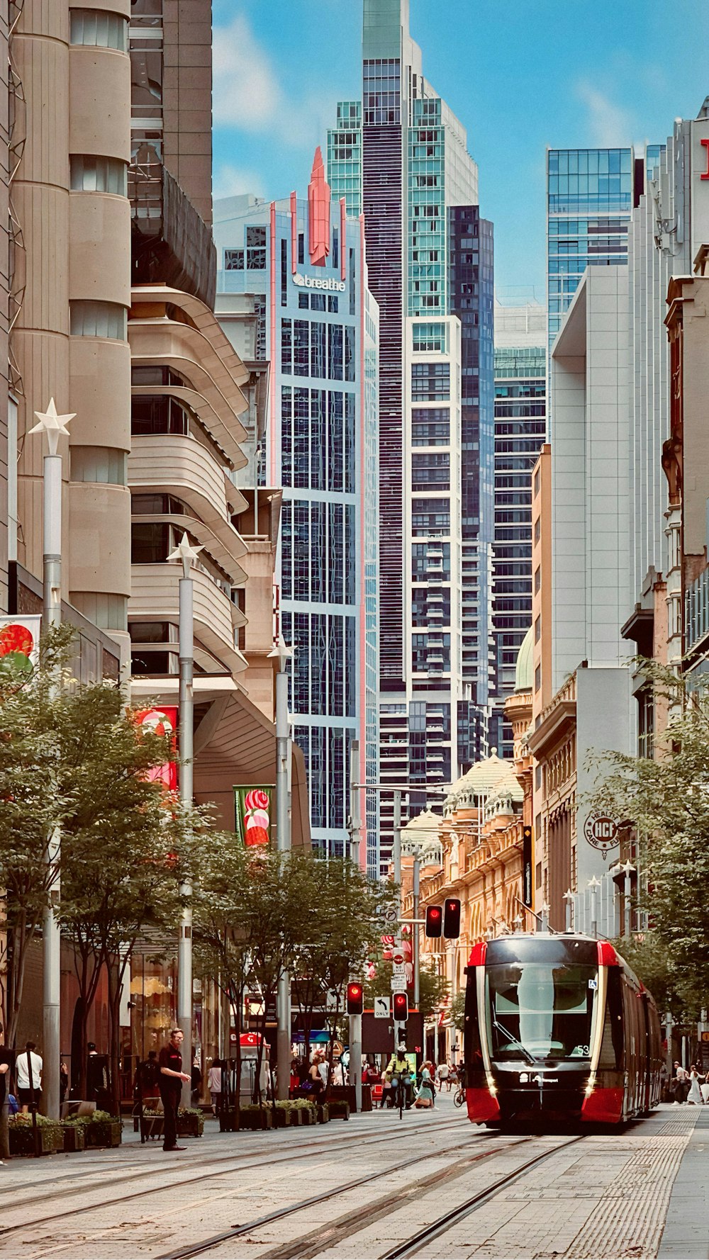 a trolley car on a city street with tall buildings in the background
