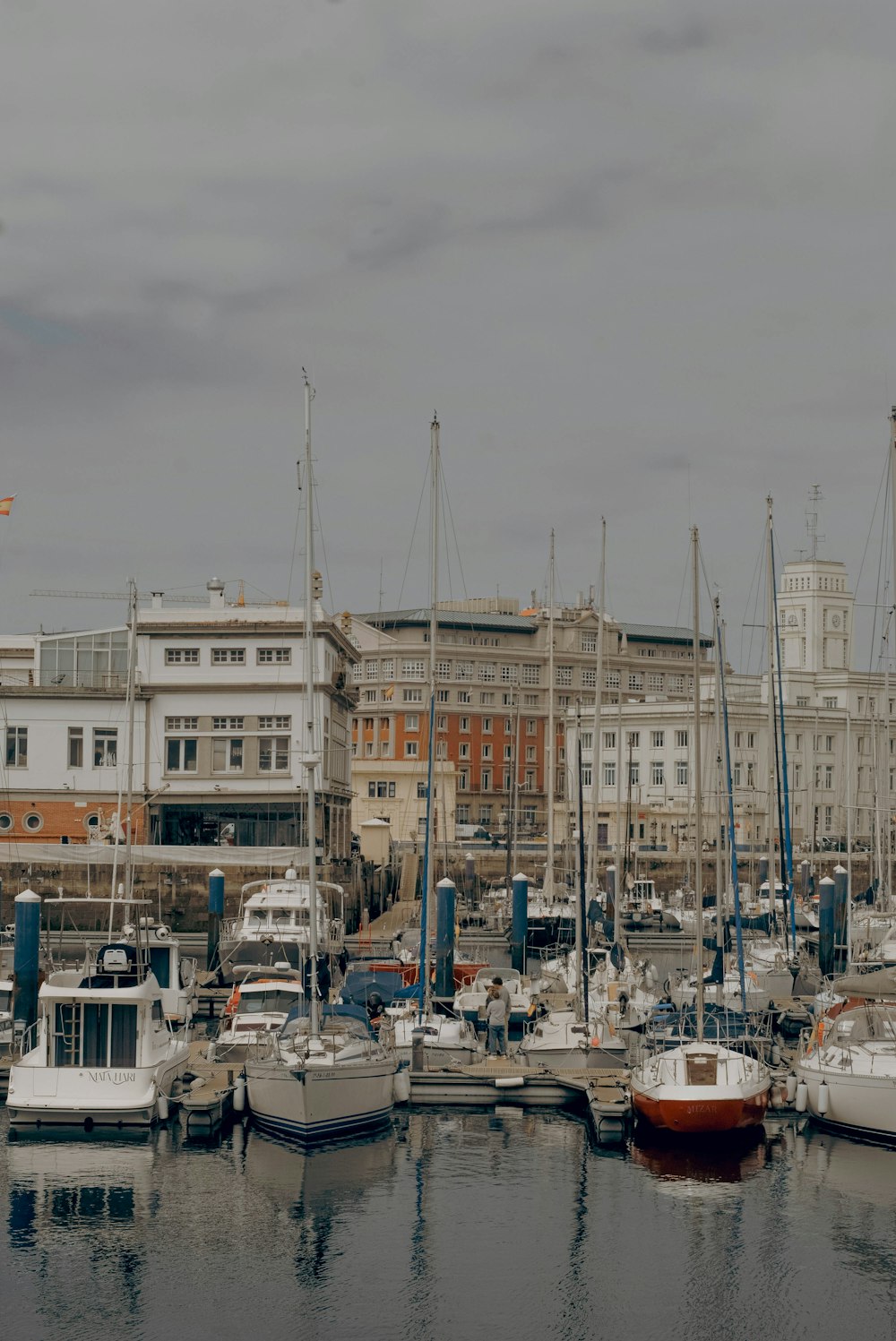 a harbor filled with lots of boats next to tall buildings